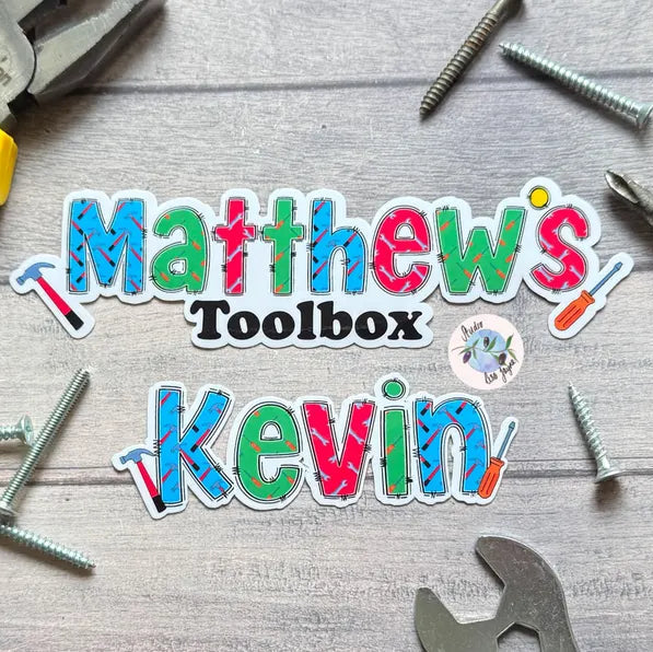 Colorful text 'Matthew's Toolbox Kevin' with tools on a wooden background DIY