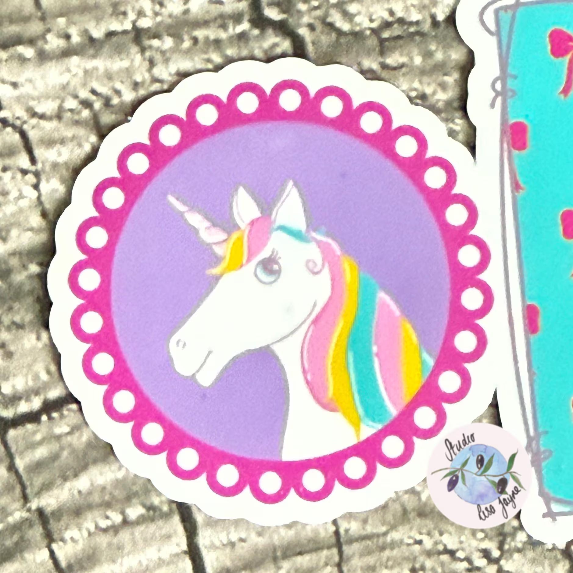 Sticker of a unicorn with a colourful mane on a textured surface