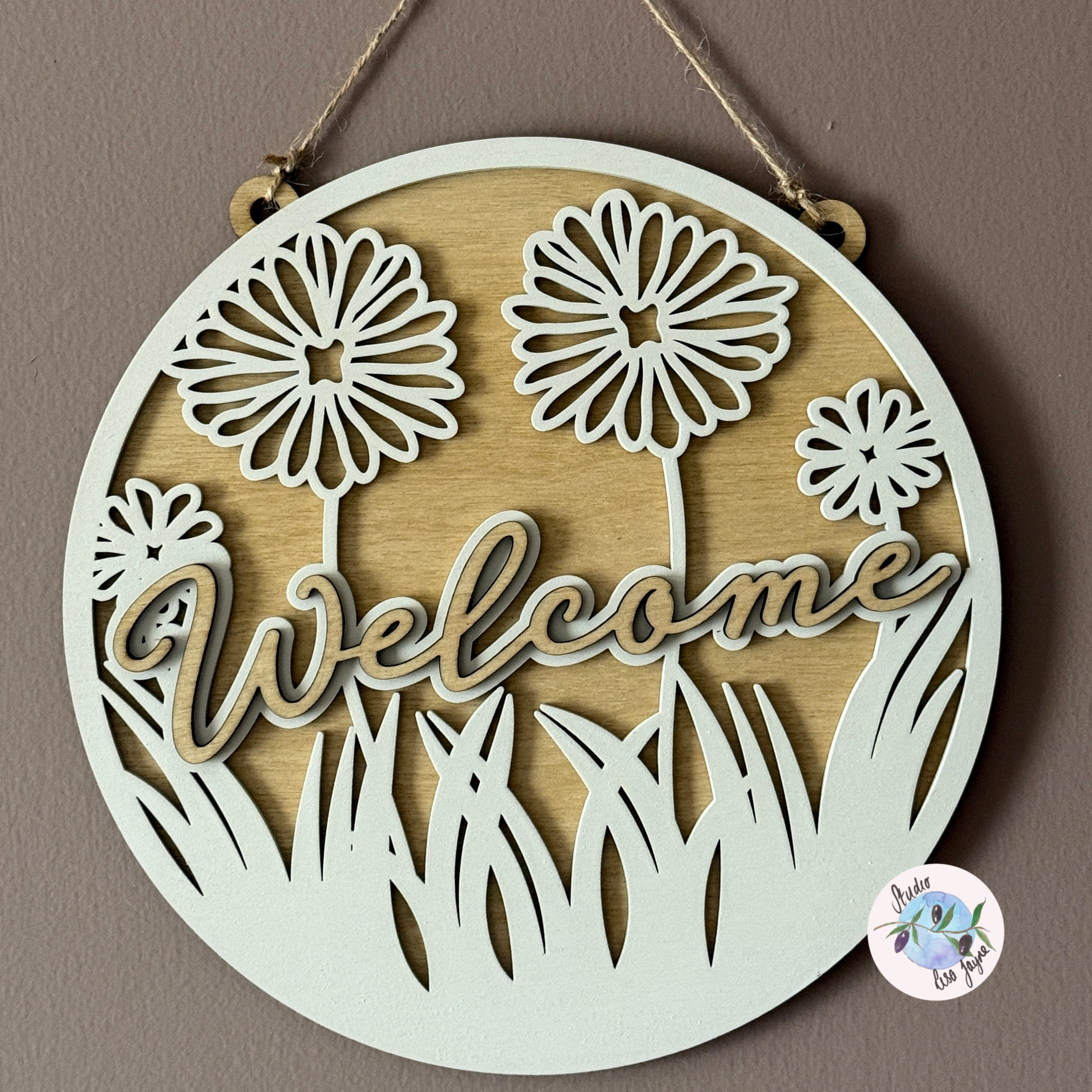 Welcome Flower Hand Painted Handmade Hanging Wooden Sign - hanging on a simple brown background with natural sunlight highlighting shadows