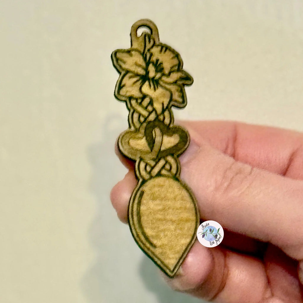 Wooden badge with welsh daffodil love spoon design held by a hand.  Ideal for St David's Day