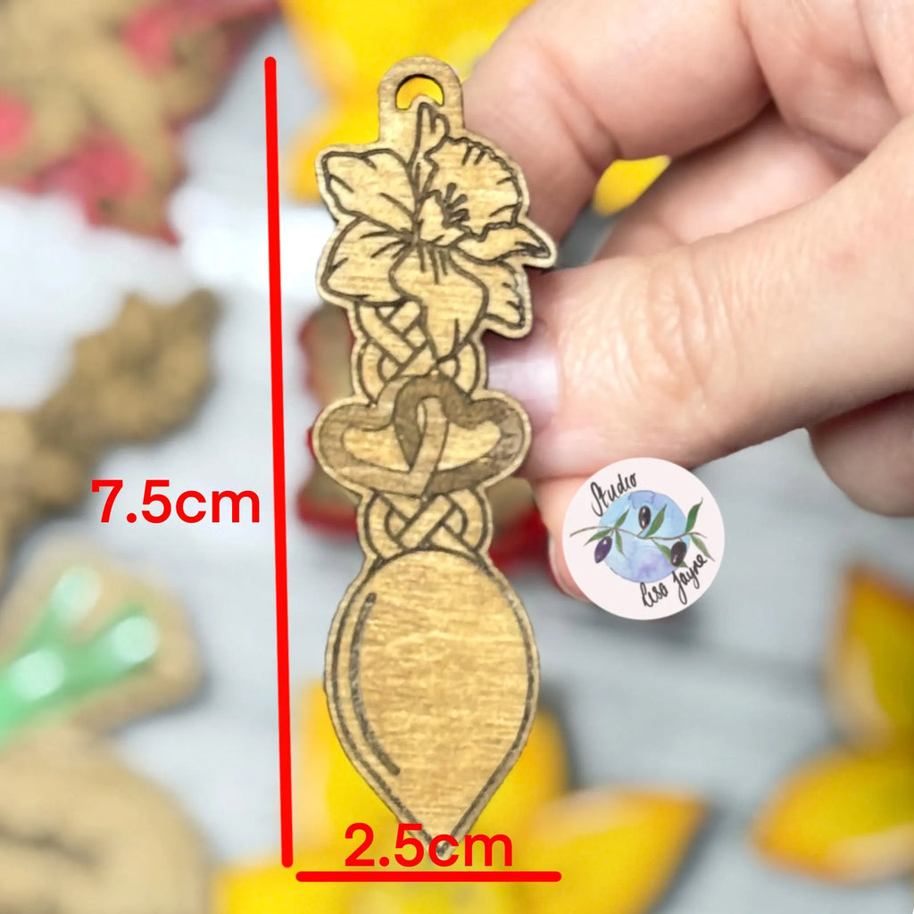Wooden brooch of welsh love spoon with measurements and a blurred background.  Ideal for St David's Day