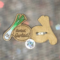 A wooden brooch featuring a leek with the words 'GWLAD, GWLAD' from the Welsh National Anthem.  Stylized representation of a leek in this ideal badge for St David's Day