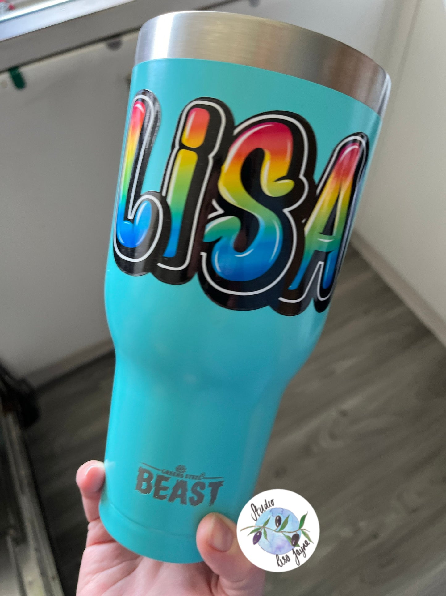 Rainbow style graffiti name sticker on a drink bottle