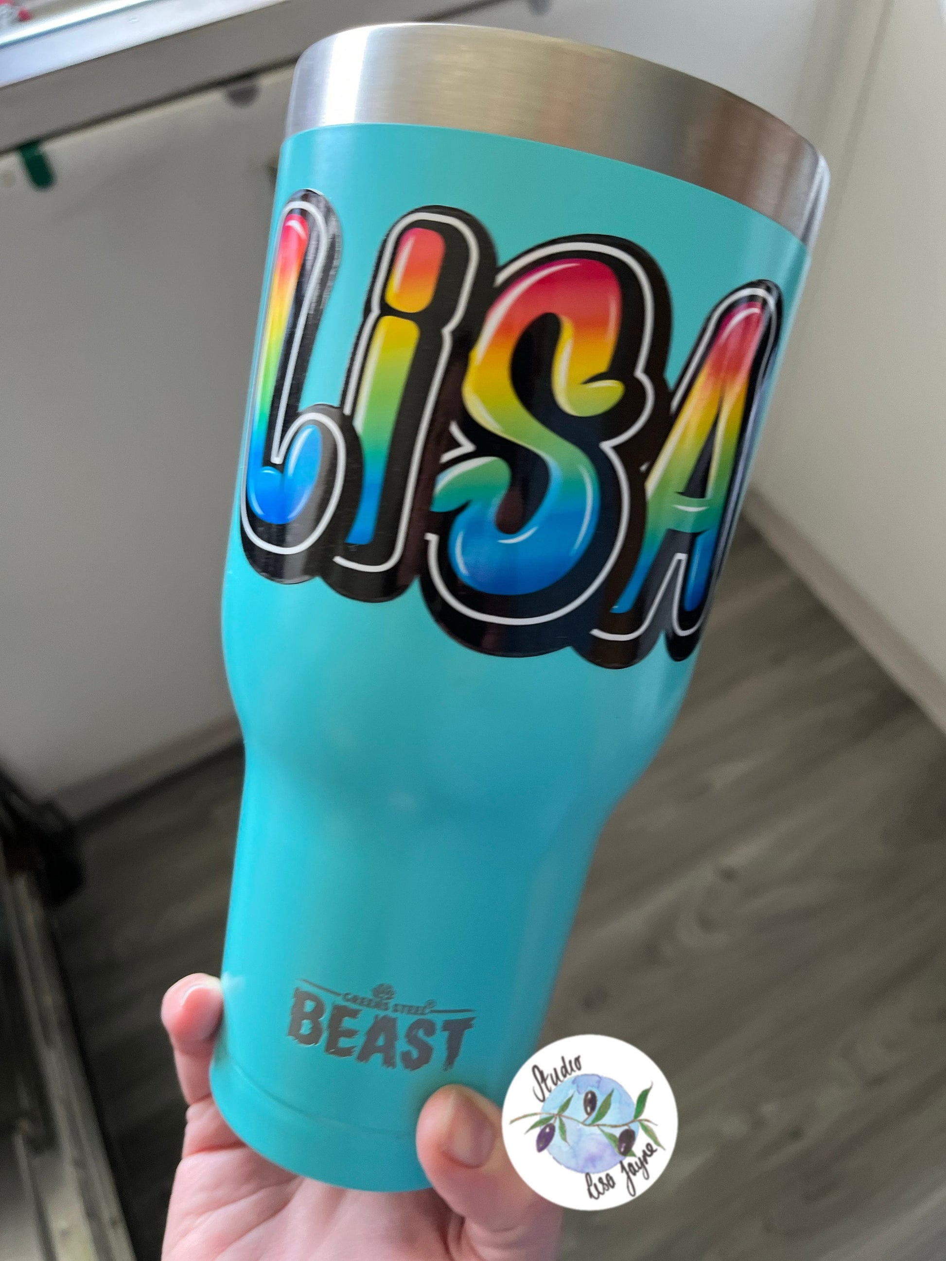 Rainbow style graffiti name sticker on a drink bottle