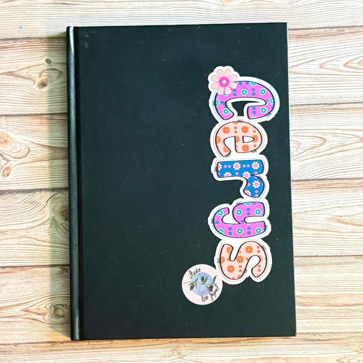Retro Floral Personalised Name Waterproof Vinyl Sticker For Smooth Surfaces - a black book with colorful letters on it
