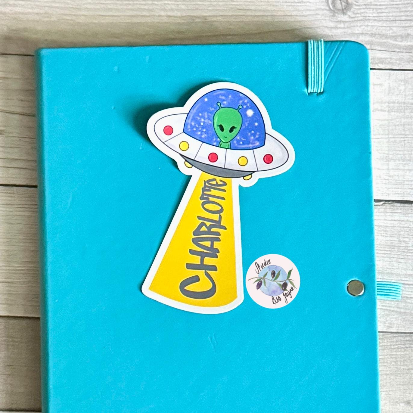 UFO Alien Name Sticker Label Kids - a blue notebook with a cartoon alien on it