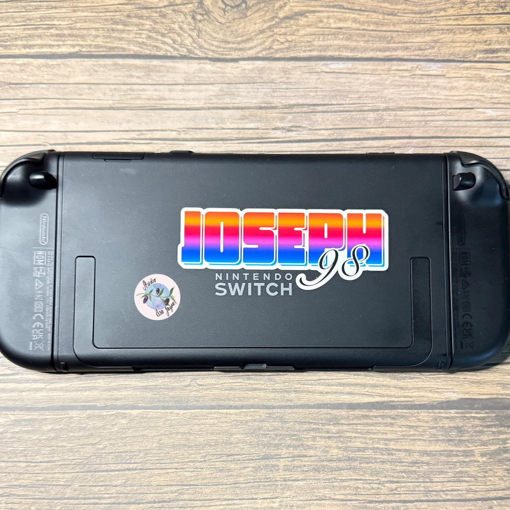 Bright Ombré multicoloured Personalised Name Waterproof Vinyl Sticker For Smooth Surfaces - a black gaming device with stickers on it