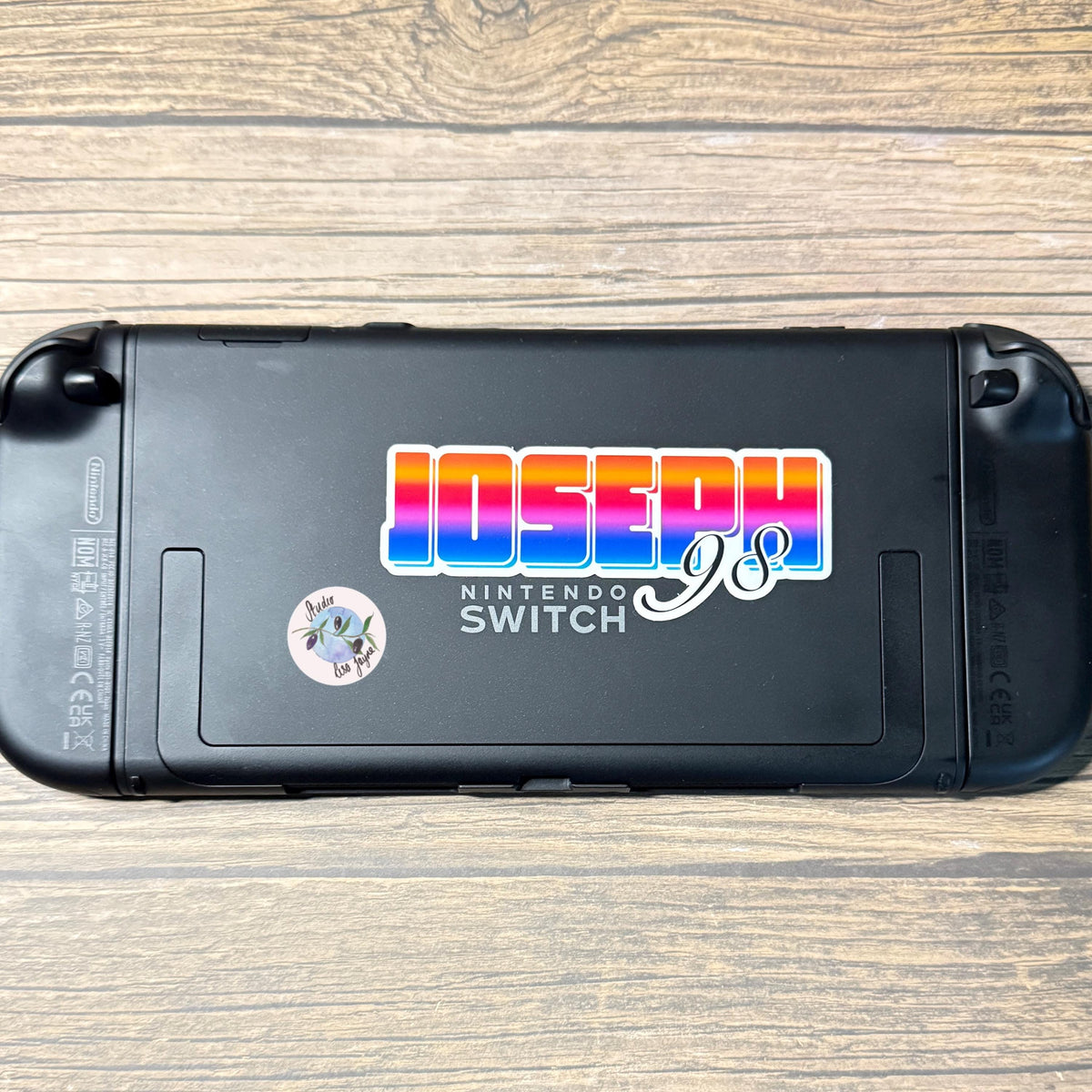 Bright Ombré multicoloured Personalised Name Waterproof Vinyl Sticker For Smooth Surfaces - a black gaming device with stickers on it