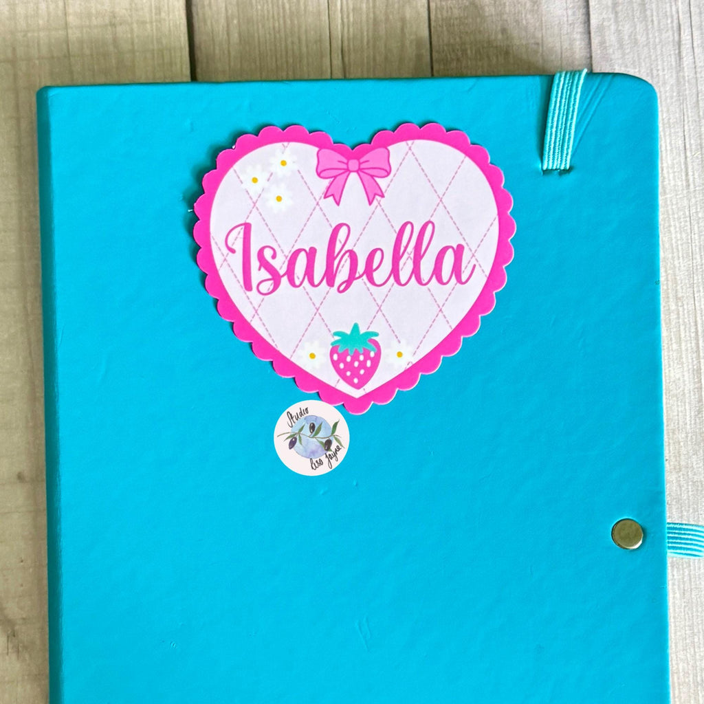 Coquette Strawberry Name Sticker Label Kids - a blue notebook with a pink heart sticker on it