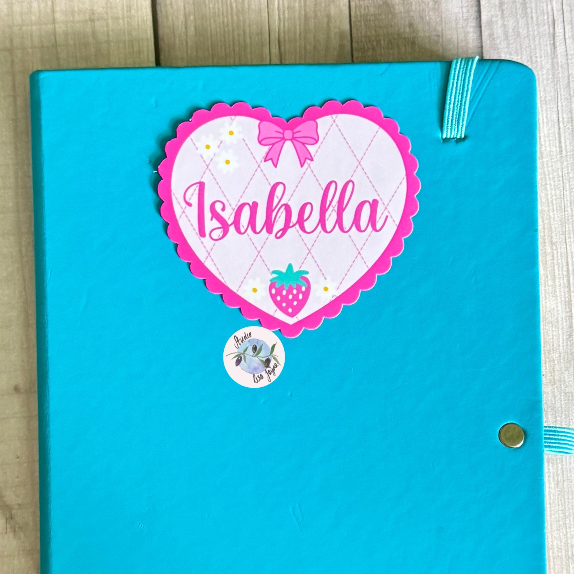 Coquette Strawberry Name Sticker Label Kids - a blue notebook with a pink heart sticker on it