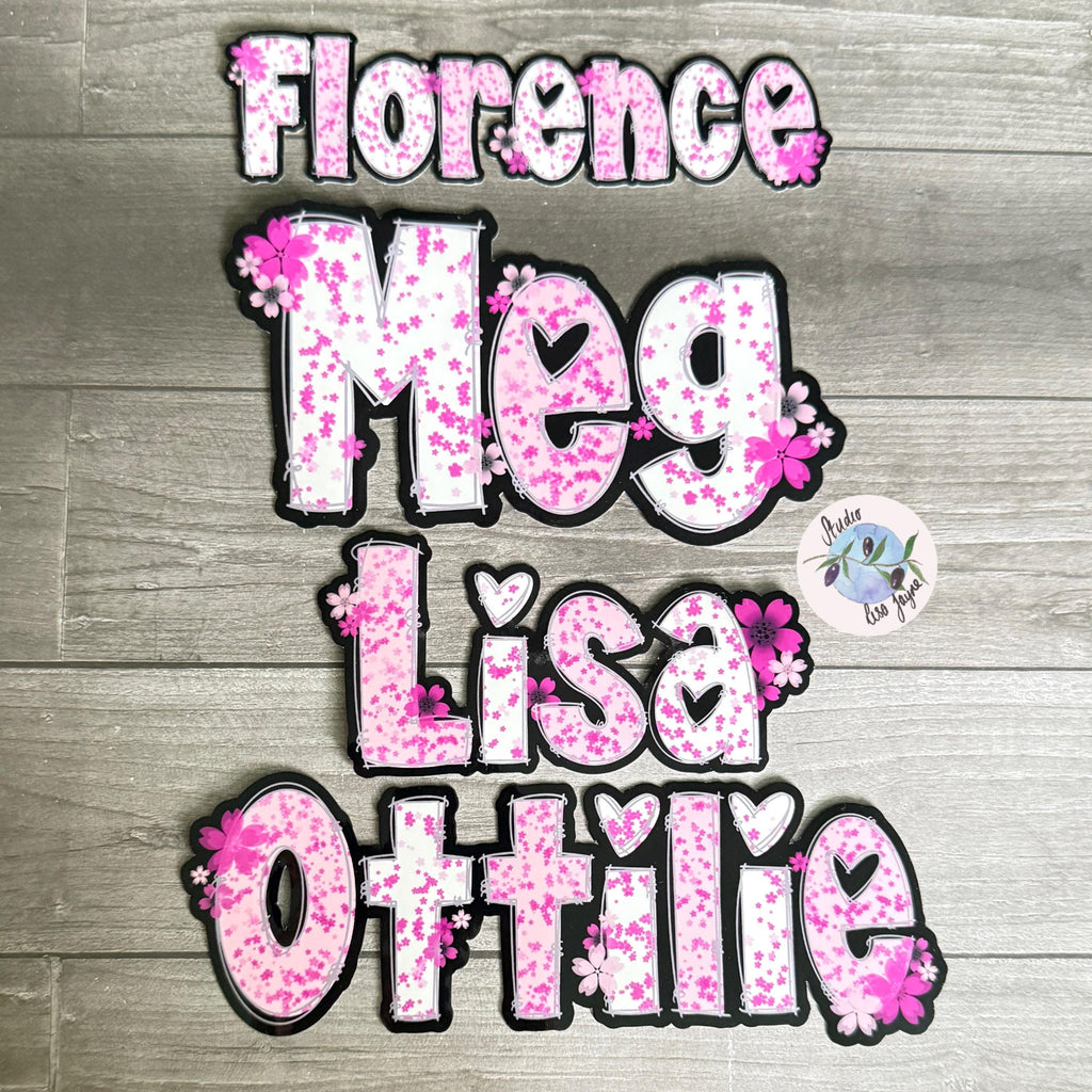 Cherry Blossom Sakura Name Sticker Label - a group of pink and white letters on a wood surface