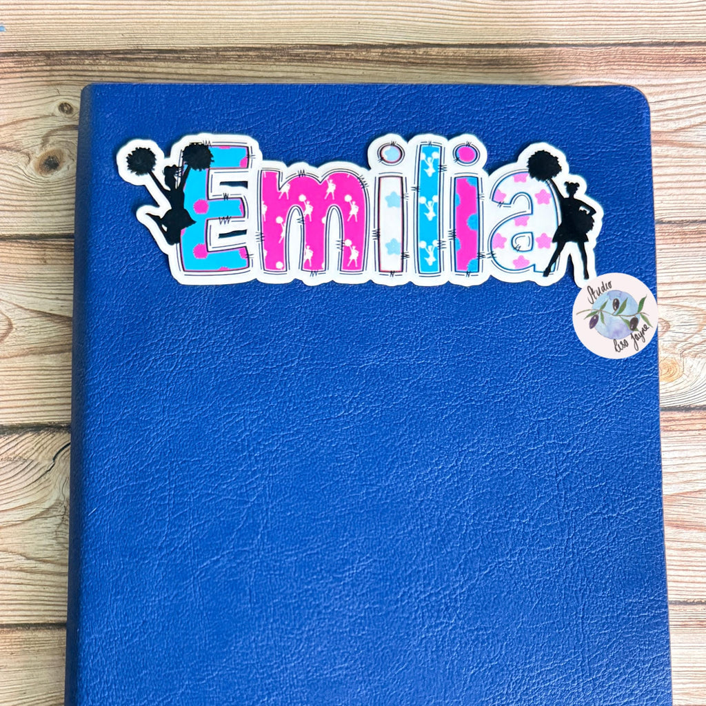 Cheerleader Name Sticker Label - a blue notebook with Emilia sticker on it