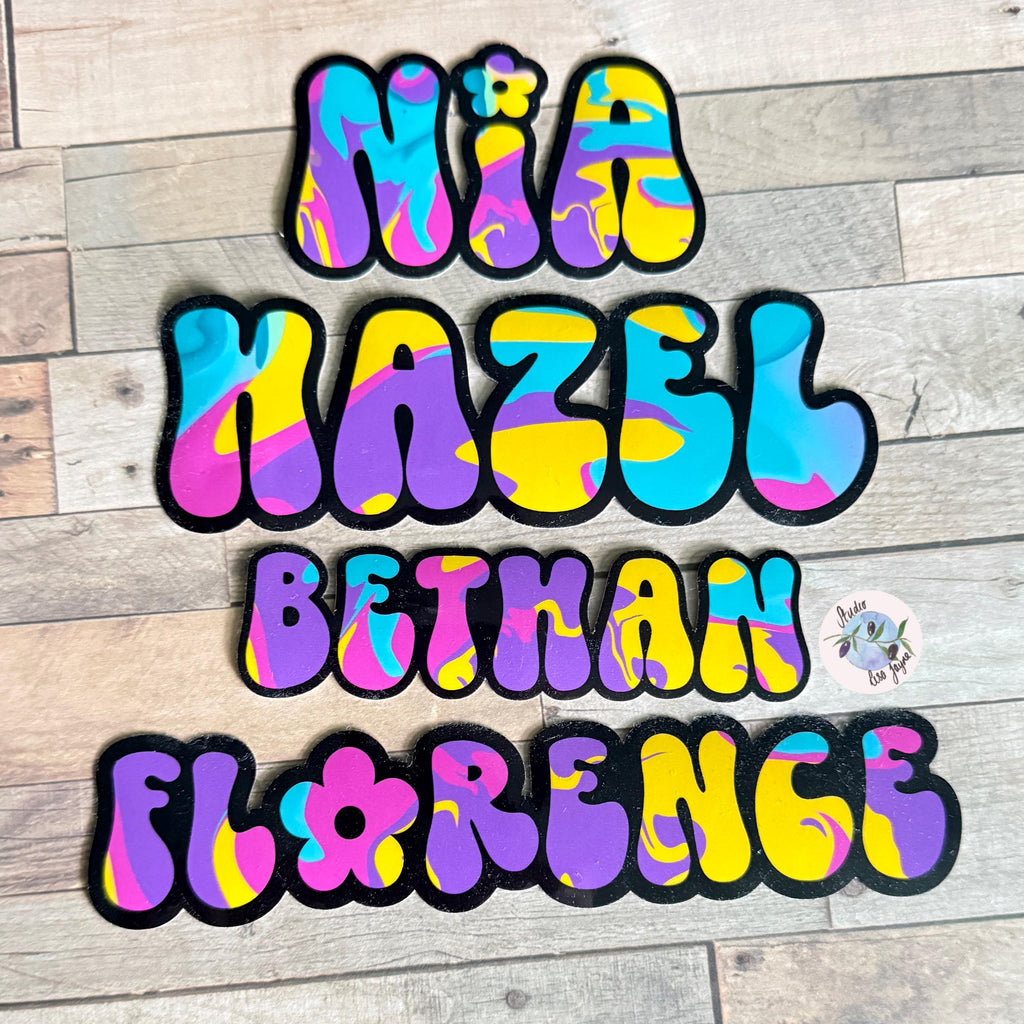 Colourful Retro Swirly Name Sticker Label - a group of colorful letters on a wood surface