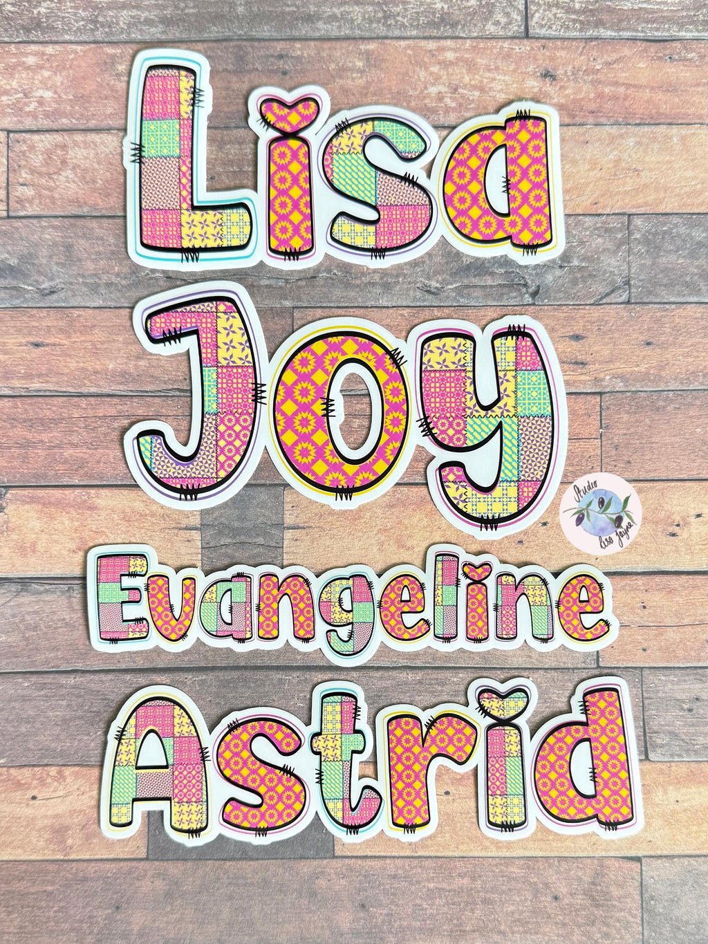 Patchwork Style Name Sticker Label - a group of colorful letters on a wood surface