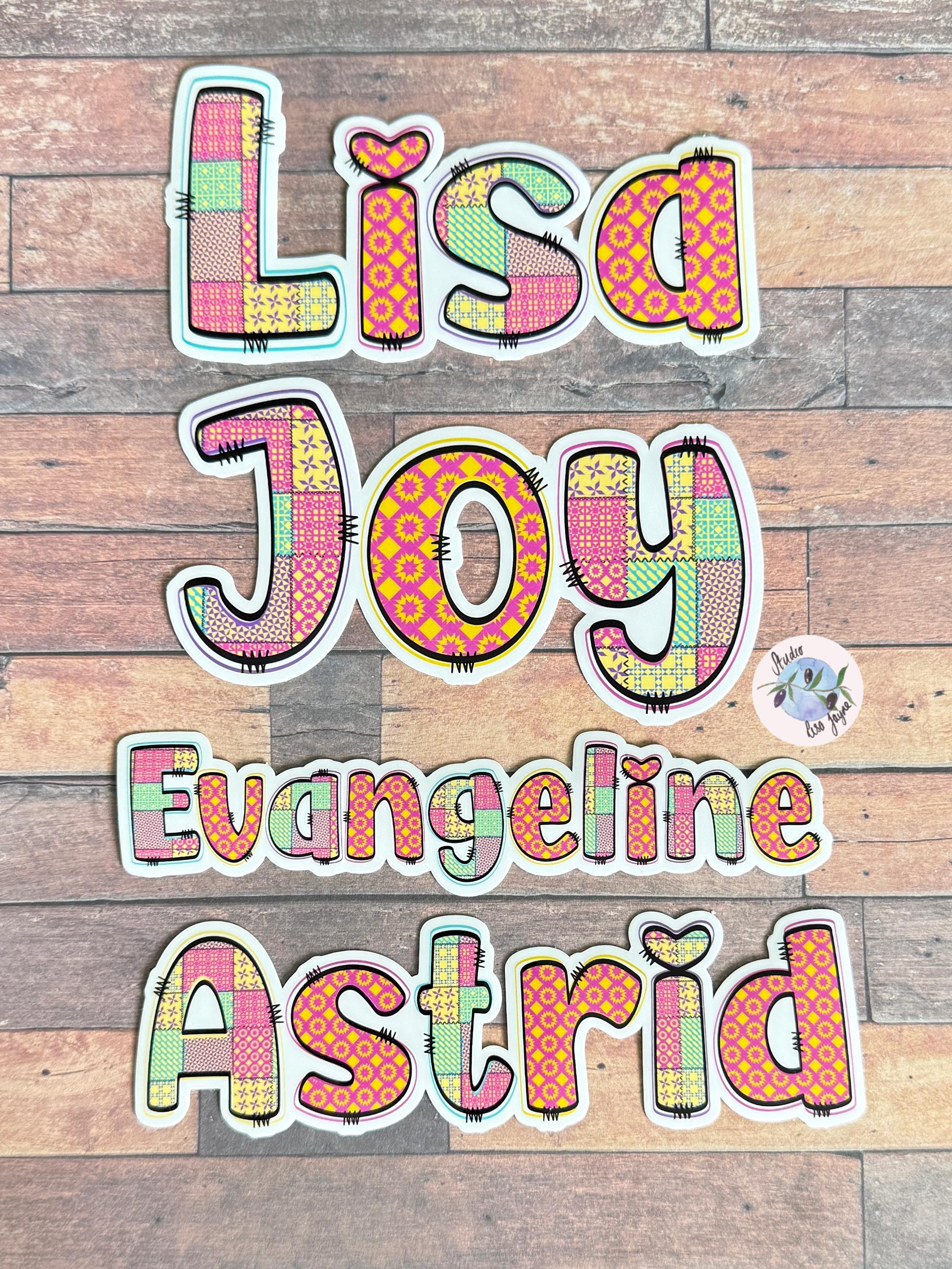 Patchwork Style Name Sticker Label - a group of colorful letters on a wood surface