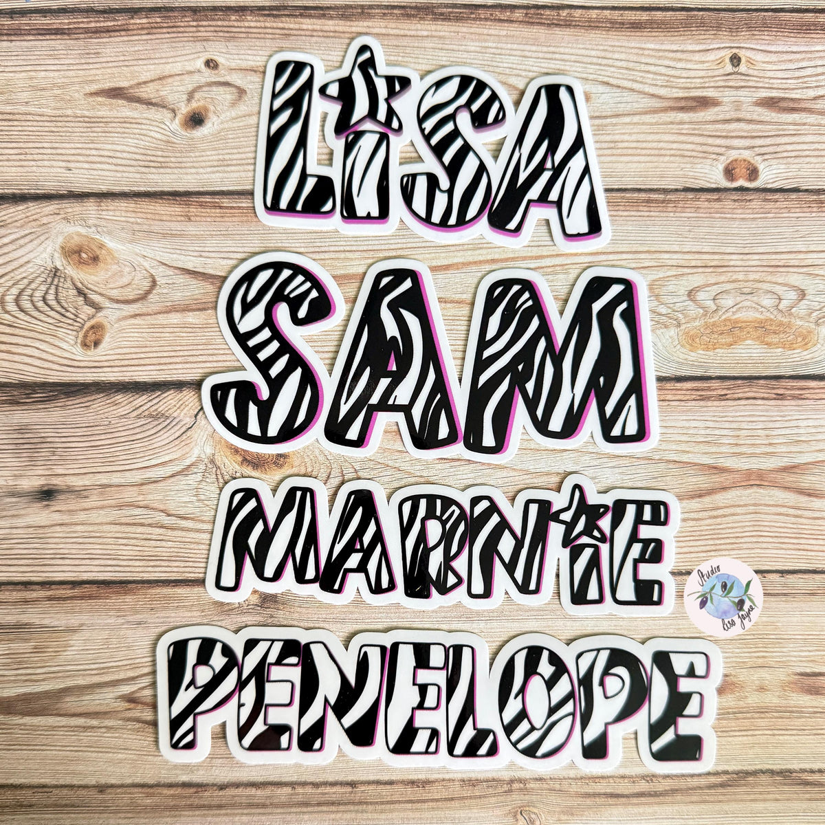 Zebra Print Name Sticker Label Kids - a group of black and white zebra letters stickers on a wood surface