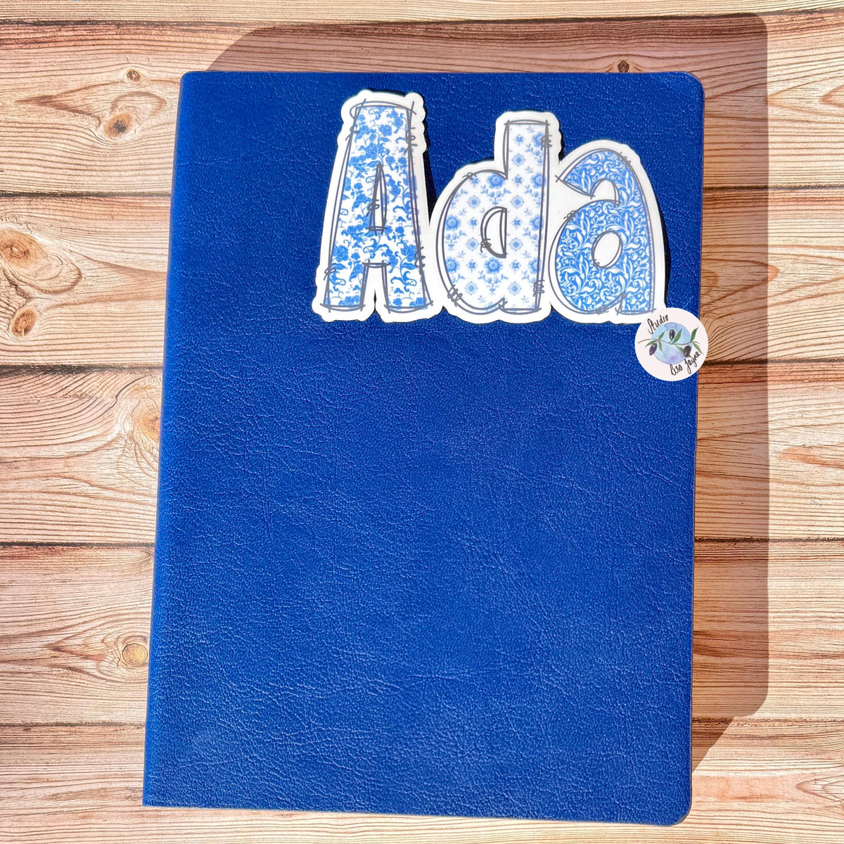 Floral Blue and White Name Sticker Label Kids - a blue notebook with a white and blue floral text on it