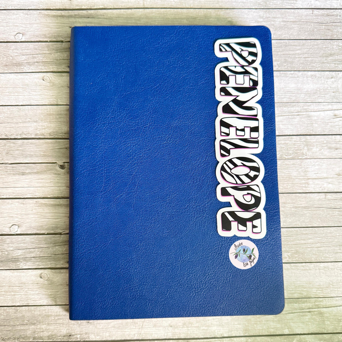 Zebra Print Name Sticker Label Kids - a blue book on a wood surface