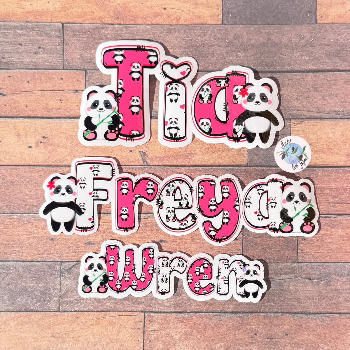 Panda Name Sticker Label Kids - a group of name stickers on a wooden backdrop.  Tia, Freya and Wren