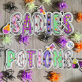 Witches and Potions Halloween Name Sticker Label Kids - a group of plastic spiders on a wood surface