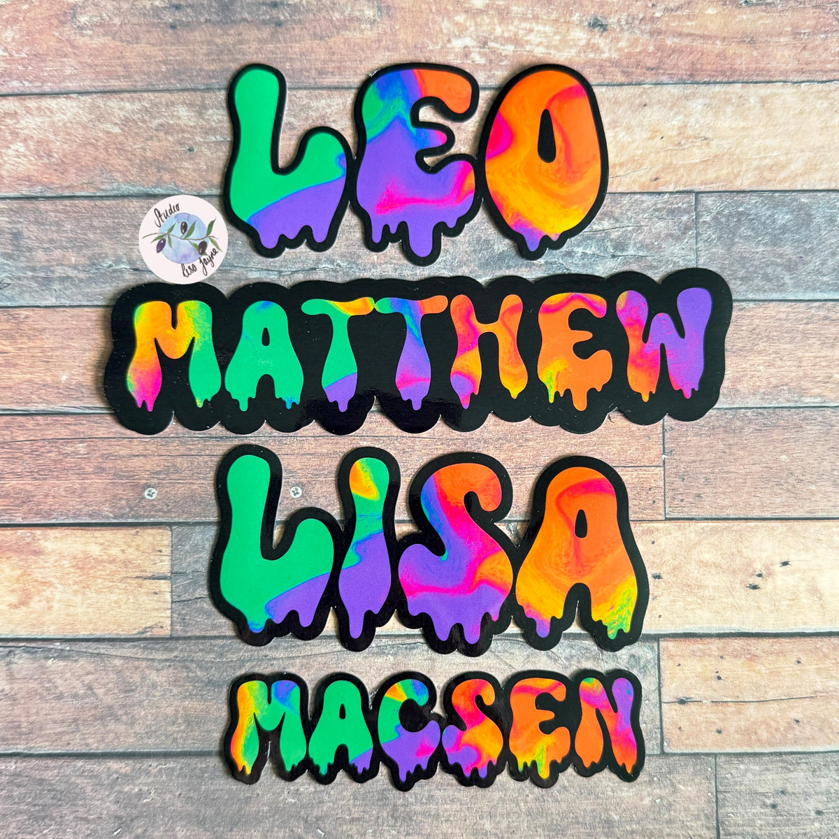 Spooky Drippy Swirly Name Personalised Halloween Waterproof Vinyl Sticker Label - a group of colorful letters on a wood surface