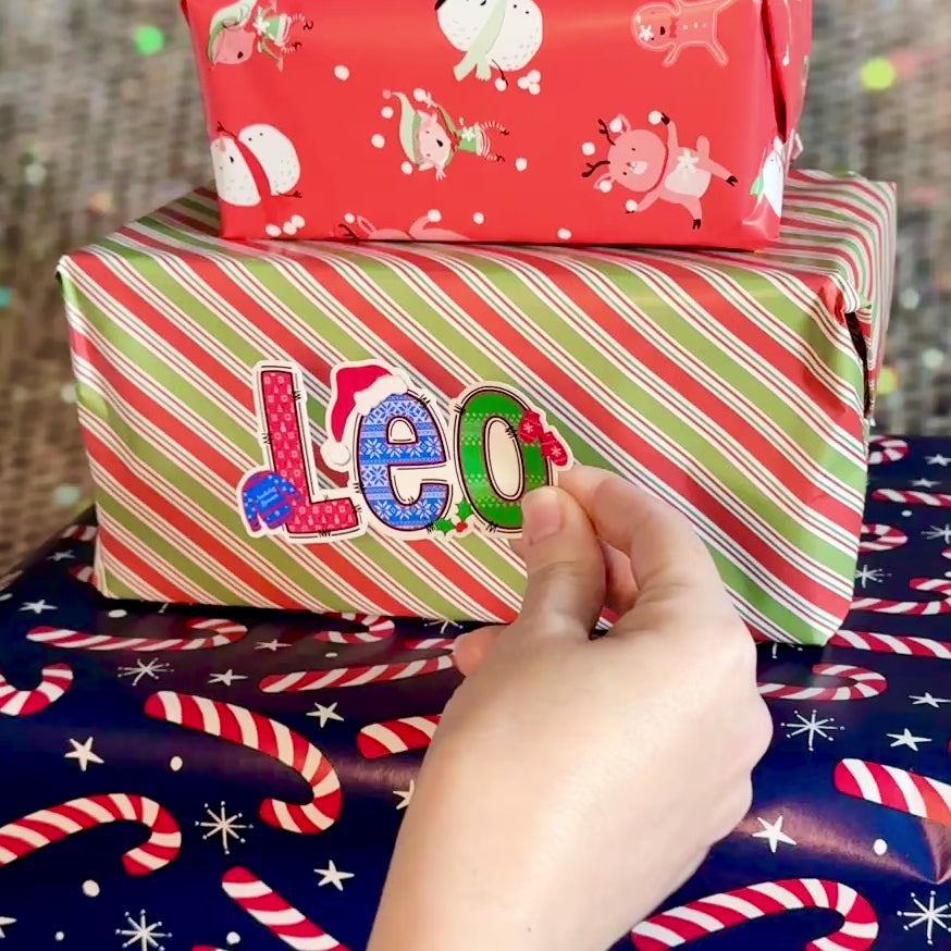 Colorful Christmas Jumper Vinyl decal with 'Lisa' applied to a wrapped christmas present box