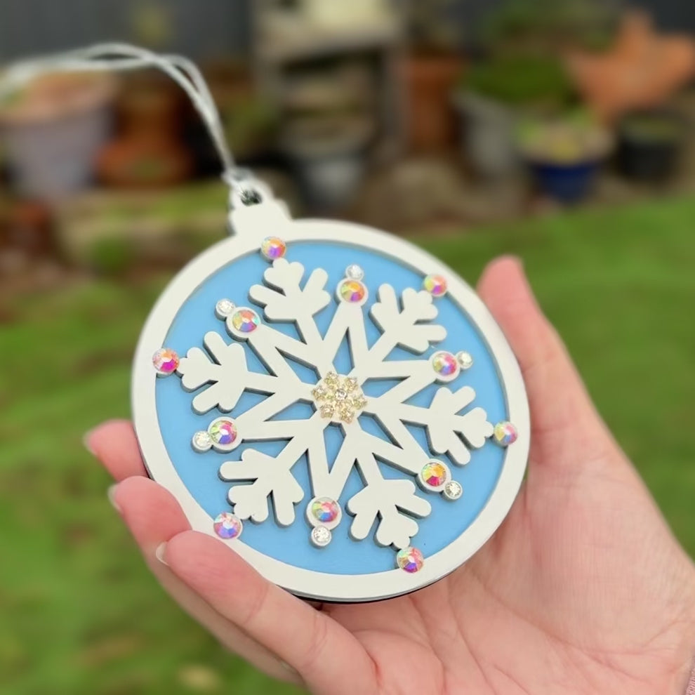 Decorative snowflake Christmas Tree ornament with rhinestones in a winter garden